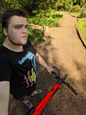 Photograph of myself with a bright orange fixie bicycle